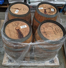 Four wooden barrels with visible branding and labels, wrapped in plastic on a pallet.