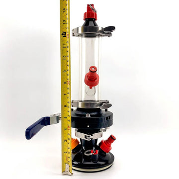 Clear cylindrical device with red and blue components, height measured by a tape measure on a white background