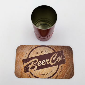 Wooden coaster with 'BeerCo' logo and a metal cup on a white background