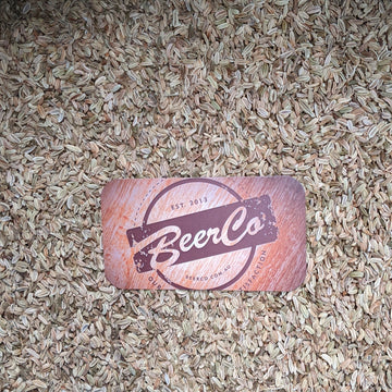 Card with 'BeerCo' logo on a bed of small seeds