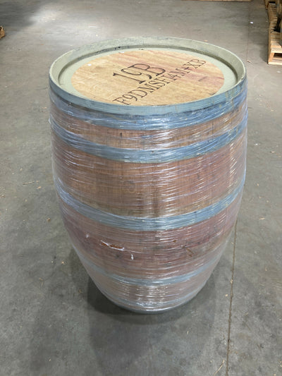 French Oak ex Wine barrel with metal hoops on a concrete floor
