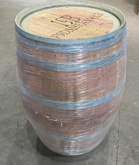 Wooden barrel with blue wrap on a concrete floor