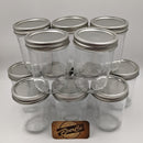 Clear glass jars with metal lids arranged in a pyramid formation on a white background, with a 'BeerCo' branded wooden coaster.