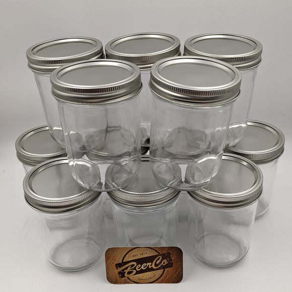 Clear glass jars with metal lids arranged in a pyramid formation on a white background, with a 'BeerCo' branded wooden coaster.