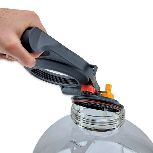 Hand using a black and red tool to open a clear plastic container on a white background