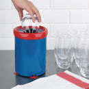 Blue and red trash can with a hand disposing of a glass, surrounded by empty glasses on a kitchen counter.