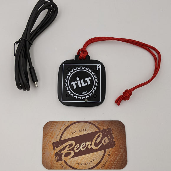 Black device with red string, black cable, and wooden coaster with 'BeerCo' branding on a light gray background.
