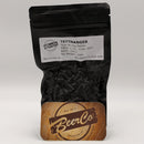 Black bag of Tettnanger hop pellets with a wooden coaster featuring BeerCo logo on a white background