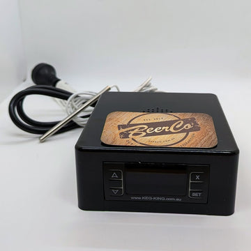 A black temperature controller device with a brand logo 'BeerCo' on the front panel, alongside a temperature probe and cables.